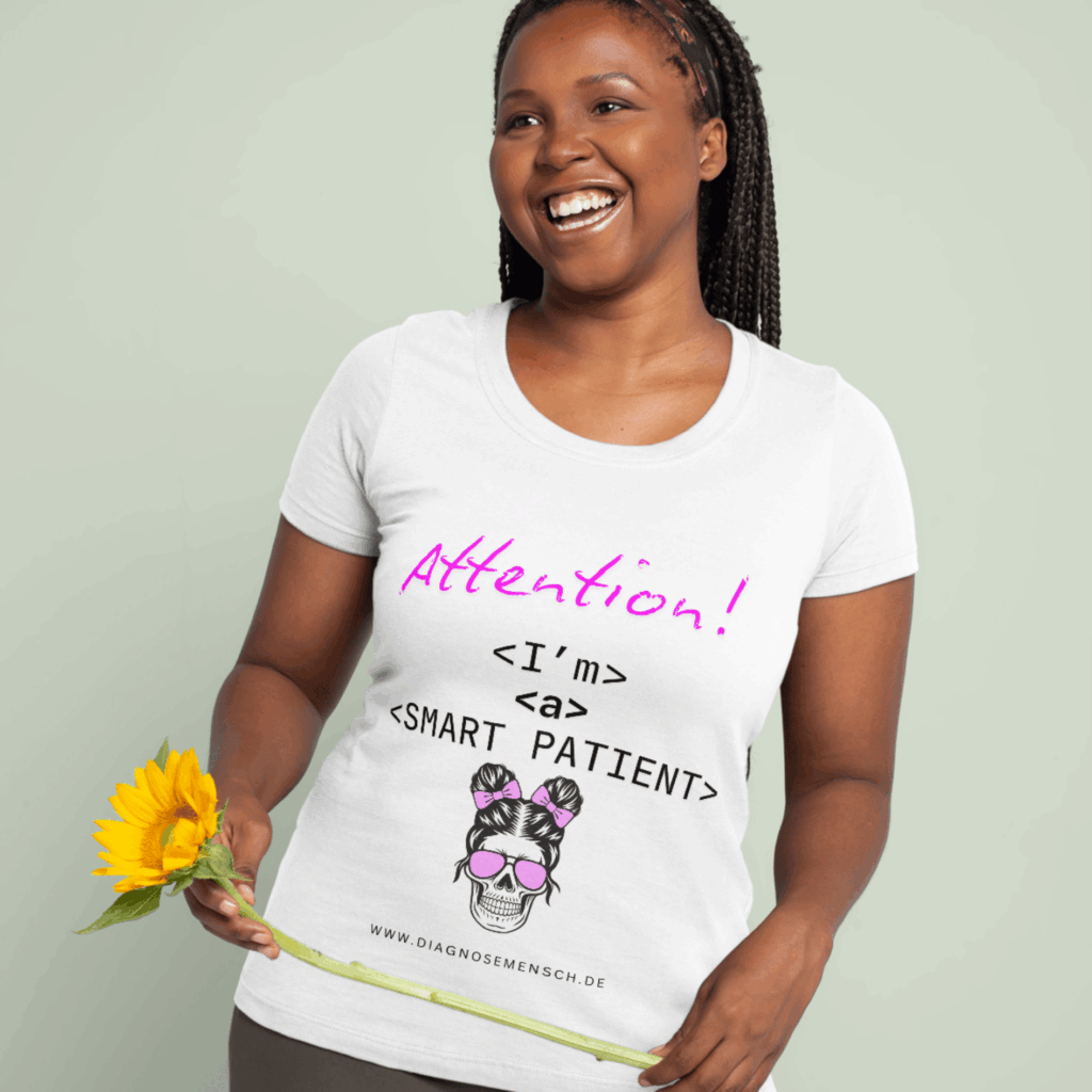 eine junge frau mit dunkler hautfarbe und schwarzen langen haaren lächelt. sie trägt ein weißes t shirt mit der aufschrift attention i'm a smart patient. darunger ist eine totenkopffrau mit pinker sonnenbrille und pinken haarbändern. und der aufschrift www.diagnosemensch.de