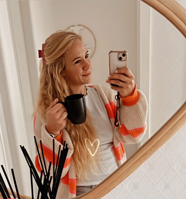 Jasmin, junge frau - ca. 30 Jahre - mit langen blonden haaren steht vor dem spiegel und fotografiert sich.
